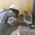 Cook, Kierko, removing ash from one of the stoves