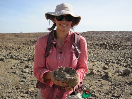 Kate picks up a chunk of petrified wood. This environment was quite different from today.