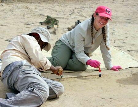 Jen and Tadele carefully brush off the surface of their excavation square.