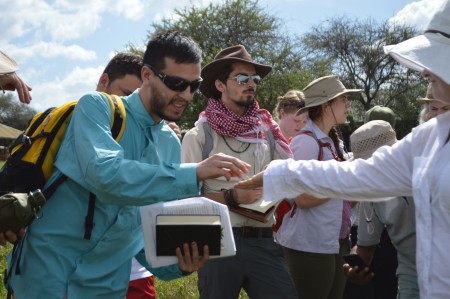 TA Hilary passes a leaf from a mint plant to student Ryan so that he can observe its distinctive scent for identification (Photo by Martha N. Mutiso).