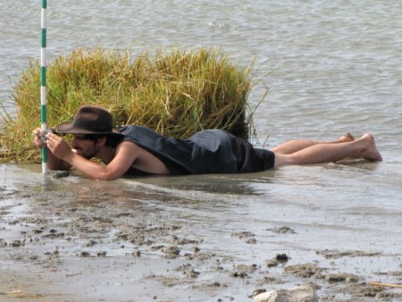 Getting geological data can be messy work. Evan gets down on the shore to level the jacobstaff with a Brunton compass.