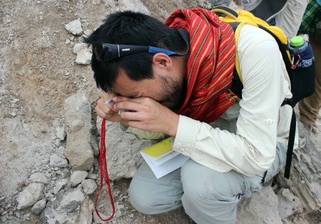 Ryan uses a hand lens to look closely at the glass particles in the tuff.